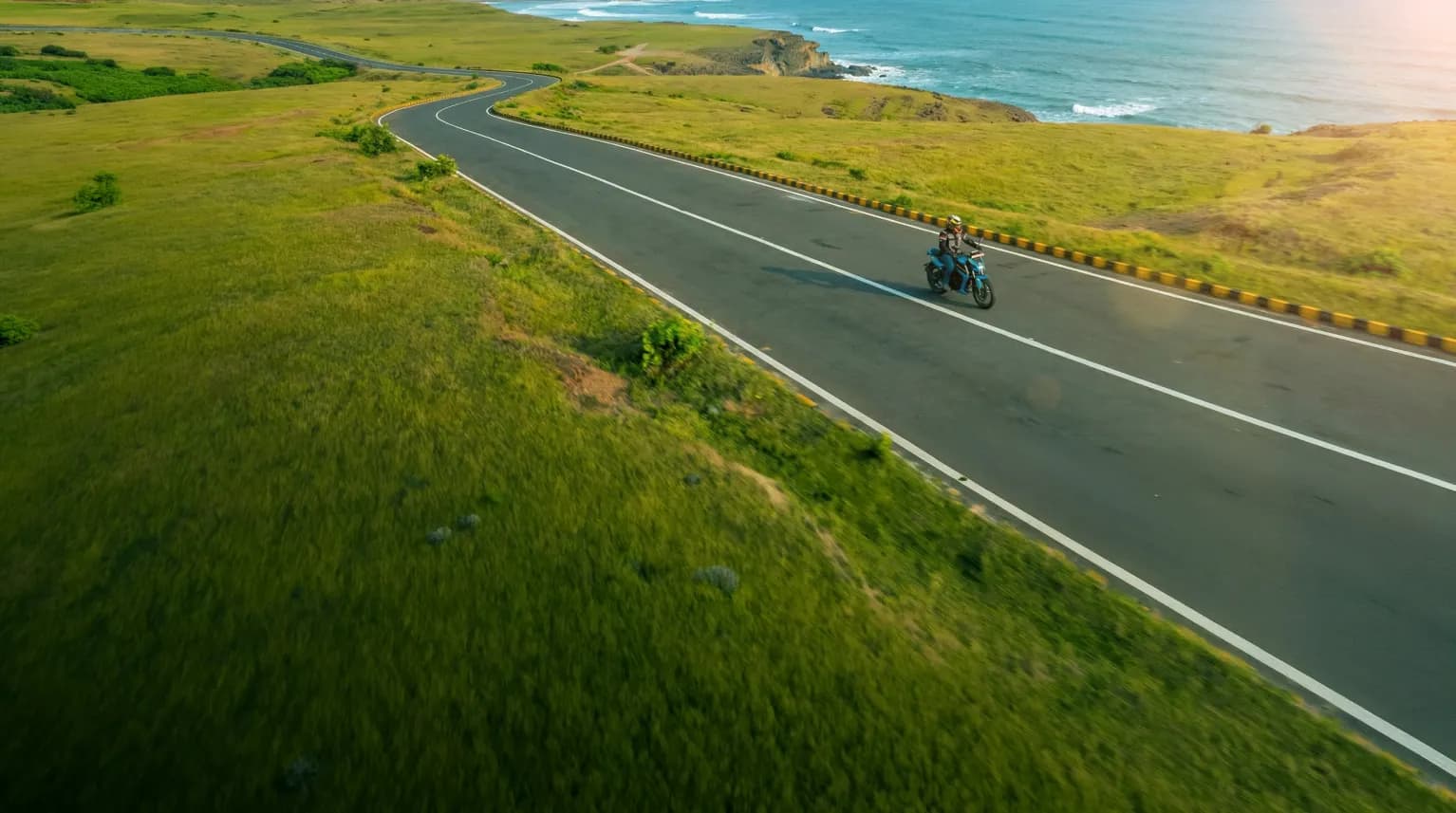Scenic coastal road with motorcycle rider